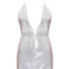 A silver, sequined mini dress with a plunging V-neckline and thin, criss-cross spaghetti straps. The dress has a fitted silhouette and an iridescent shimmer that reflects light, creating a sparkling effect across the fabric.
